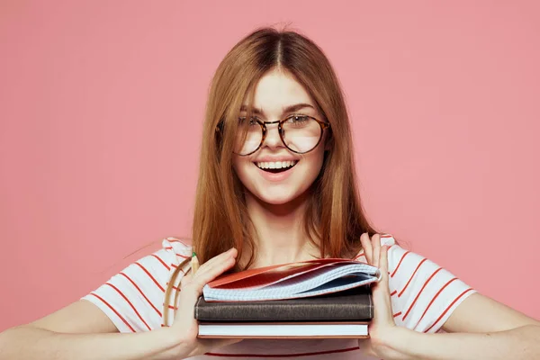 Jovem estudante com livros sobre óculos de fundo rosa no instituto de educação facial vista cortada — Fotografia de Stock