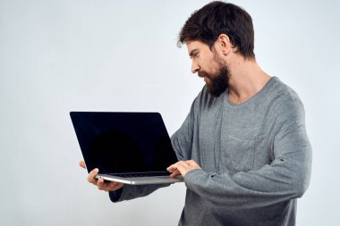 Gri kazaklı bir adam dizüstü bilgisayarlı. Yaşam tarzı teknoloji iletişimi internet işi yapıyor.