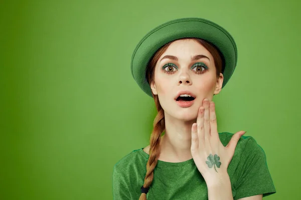 Belle fille avec un trèfle sur sa main sur un fond vert vacances St. Patricks Day chapeau amusant sur sa tête — Photo