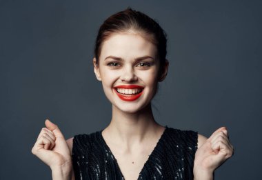 Gri arka plan üzerinde çıplak omuzları olan siyah elbiseli hoş bir bayan.