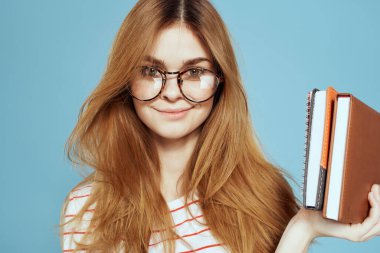 Notları ve mavi gözlükleri olan enerjik bir bayan öğrenci.