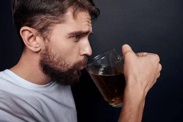 Man med en mugg öl i en vit t-shirt känslor livsstil berusad på en mörk isolerad bakgrund — Stockfoto