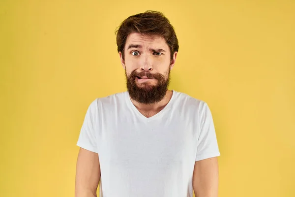 Un hombre en una camiseta blanca gestos con sus manos estilo de vida recortado ver fondo amarillo más divertido —  Fotos de Stock