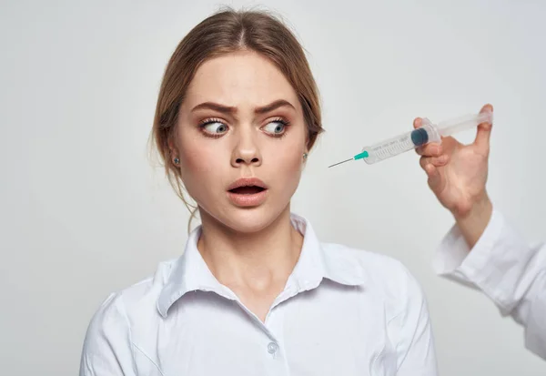 Rädd kvinna och spruta med nål nära ansiktet — Stockfoto