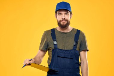 Üniformalı işçi, sarı arkaplan duygusuna hizmet ediyor.