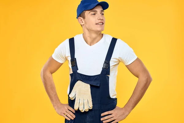 Hombre en uniforme de trabajo emociones prestación de servicio de entrega de fondo amarillo — Foto de Stock