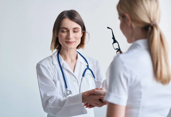 女性医師と眼鏡を手に軽い背景患者通信 — ストック写真
