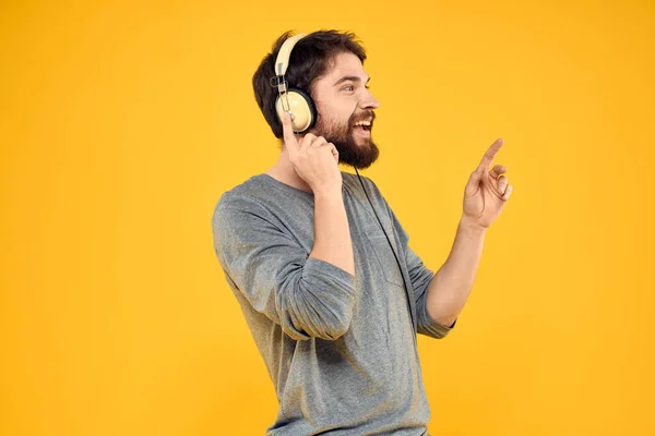 Man met koptelefoon muziek lifestyle lifestyle technologie gele achtergrond — Stockfoto
