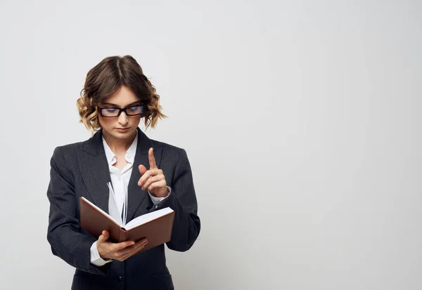 Donna d'affari con un libro in mano su uno sfondo leggero vestito classico acconciatura alla moda Copia Spazio — Foto Stock