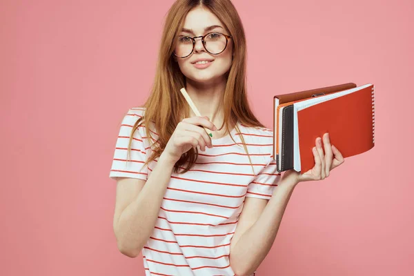 Jovem estudante com livros sobre óculos de fundo rosa no instituto de educação facial vista cortada — Fotografia de Stock