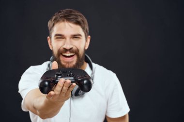 Elinde joystick olan bir adam kulaklıklar teknoloji eğlence oyun yaşam tarzı karanlık izole arka plan