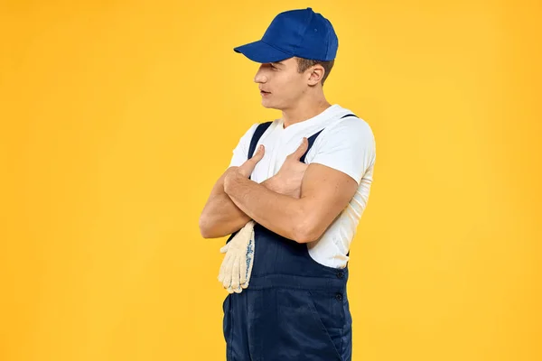 Man in working uniform emotions rendering service delivery service yellow background — Stock Photo, Image