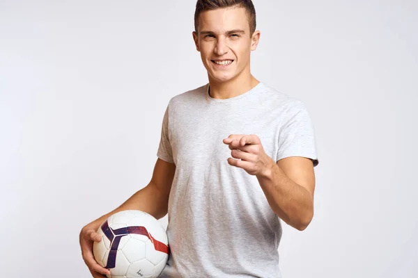Felice uomo con palla in mano e in t-shirt bianca su sfondo chiaro gesticolando con le mani ritagliato vista — Foto Stock