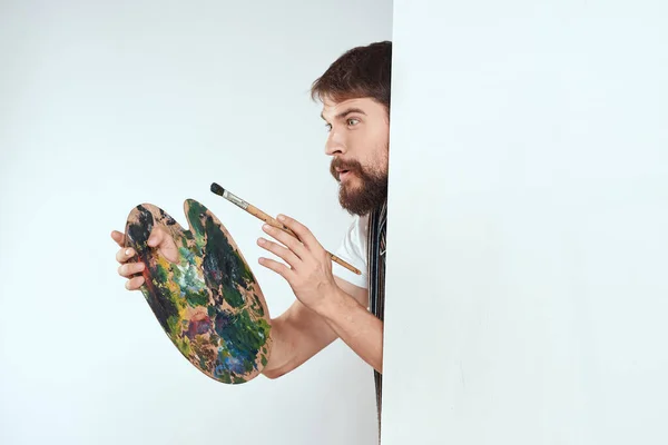 Artista masculino escondido detrás de una paleta de caballete dibujo arte — Foto de Stock