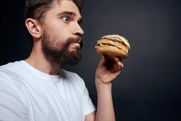 Man eating hamburger fast food restaurant Gourmet eating dark background
