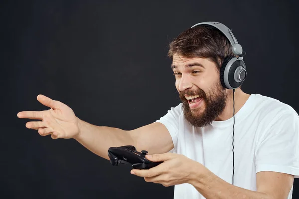 Άνθρωπος σε ακουστικά με gamepad διασκέδαση ψυχαγωγία παιχνίδια lifestyle σκούρο φόντο — Φωτογραφία Αρχείου