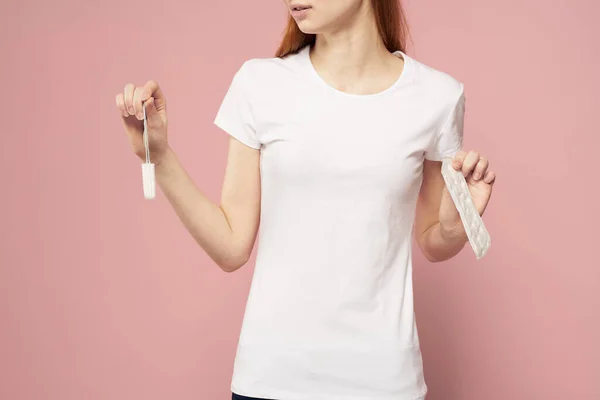 Meisje met een pad en tampons in de hand roze achtergrond menstruatie kritieke dagen hygiëne — Stockfoto