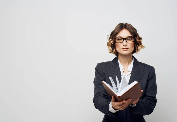 Donna d'affari con un libro in mano su uno sfondo leggero vestito classico acconciatura alla moda Copia Spazio — Foto Stock