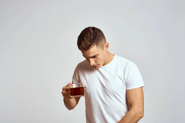 Mec avec une tasse de thé dans la main et un t-shirt blanc incliner la tête vers le bas — Photo