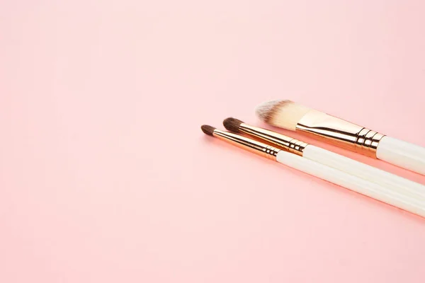 Cepillos de maquillaje sobre un fondo rosa en diferentes tamaños vista recortada —  Fotos de Stock