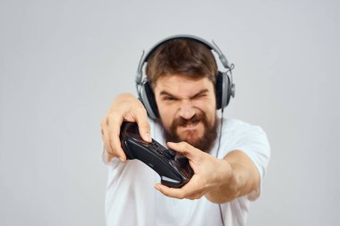 Gamepad 'li kulaklıklı bir adam hobi hayatı tarzı hafif arka planda oynuyor.