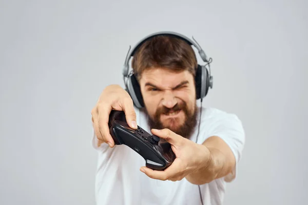Άνθρωπος σε ακουστικά με gamepad παίζει χόμπι ψυχαγωγία lifestyle φως φόντο — Φωτογραφία Αρχείου