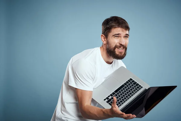 Homem emocional com laptop em mãos no fundo azul monitor teclado internet modelo recortado vista — Fotografia de Stock