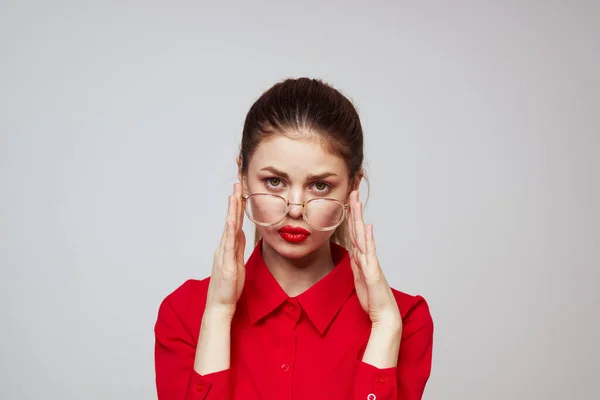 Modische Frau in einem roten Hemd auf hellem Hintergrund Spaß Emotionen helle Make-up-Brille attraktives Aussehen — Stockfoto