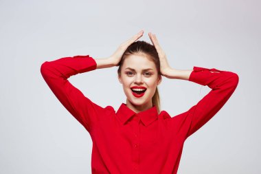 Açık arkaplanda kırmızı dudaklı bir kadının portresi. Makyaj modeli.