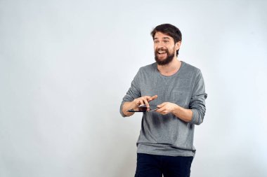 Elinde tablet, elinde internet teknolojisi olan bir adam. İletişim teknolojisi. Gri ceketli.