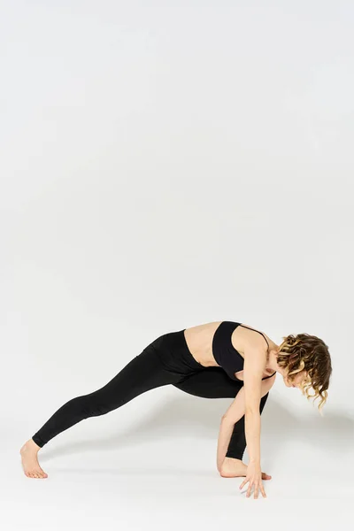 Kobieta w odzieży sportowej zajmuje się fitness wewnątrz gimnastyka szczupła postać — Zdjęcie stockowe