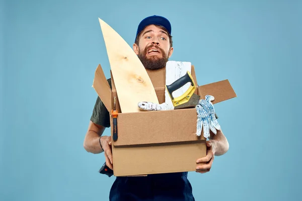 Trabajador hombre en uniforme caja herramientas construcción fondo azul — Foto de Stock