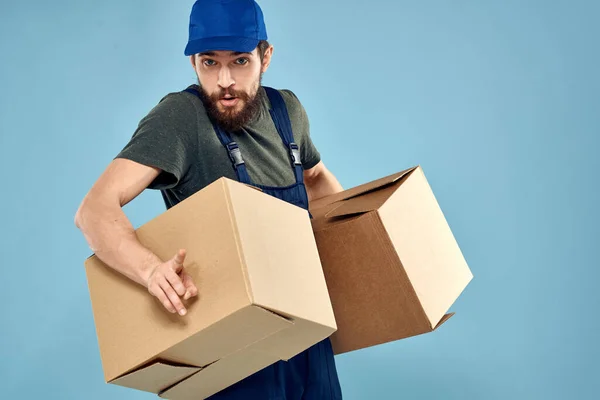 Trabalho homem caixas em mãos entrega serviço embalagem estilo de vida azul fundo — Fotografia de Stock