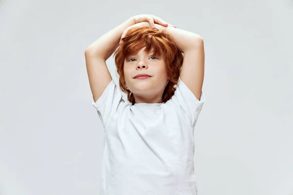 Roodharig kind hand in hand op hoofd wit t-shirt bijgesneden uitzicht — Stockfoto