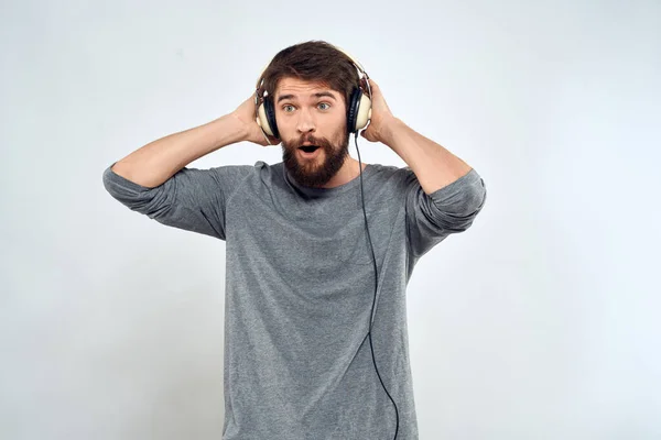 Man in hoofdtelefoon luistert naar muziek levensstijl vrije tijd licht achtergrond — Stockfoto