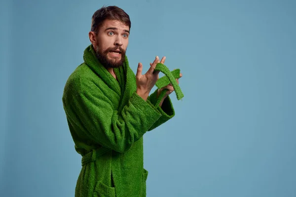 Bearded man in green robe with belt on blue background cropped view of emotion — Stock Photo, Image
