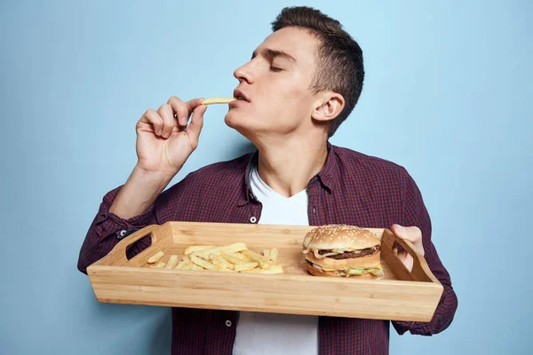 木製パレット付きの男ファーストフードフライドハンバーガー飢餓食青の背景 — ストック写真