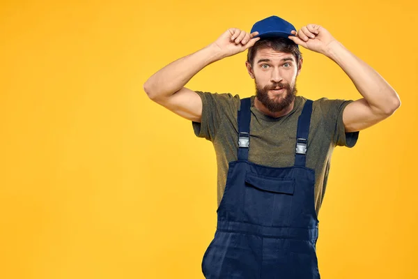 Trabajador hombre en uniforme trabajador servicio amarillo fondo emoción — Foto de Stock