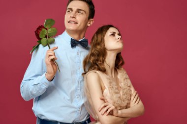 Kırmızı gülü seven romantik bir çiftin portresi izole edilmiş arka plan ve klasik gece elbisesi.