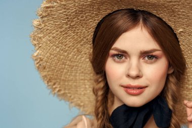 Hasır şapkalı kız portresi yakın çekim at kuyruğu eğlenceli kızıl saçlı mavi arka plan