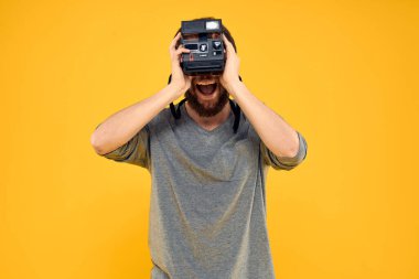 Profesyonel fotoğraf makinesi olan bir erkek fotoğrafçı. Profesyonel Yaratıcı yaklaşım stüdyo sarı arka plan