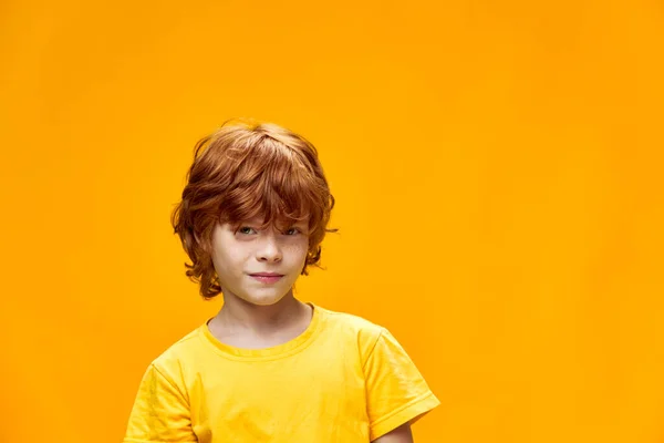 Chlapec na žlutém pozadí při pohledu vpřed oříznutý pohled — Stock fotografie
