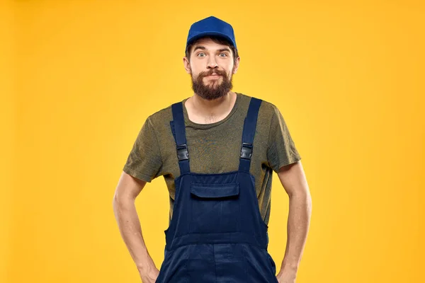 Hombre en el trabajo uniforme prestación servicio carretilla elevadora trabajo estilo de vida amarillo fondo — Foto de Stock