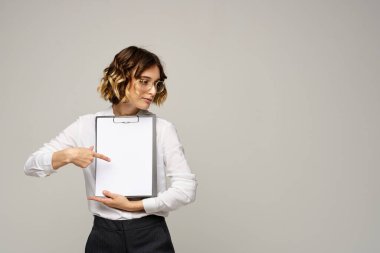 Açık tişörtlü bir iş kadını ve dosyasının içinde iş görüşü kesilmiş belgeler var.