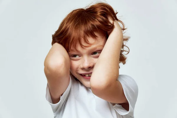 Wesoły rudy chłopiec trzyma jego głowa uśmiech przycięty widok zbliżenie — Zdjęcie stockowe