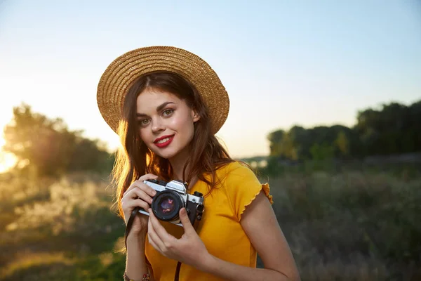 Wanita cantik memegang kamera tersenyum bibir merah topi alam — Stok Foto