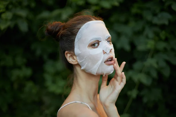 Portrét ženy s bílou maskou Držte ruku v blízkosti kosmetiky obličeje — Stock fotografie