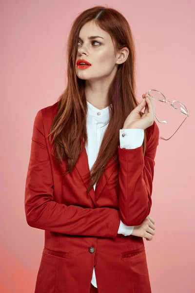 Mulher bonita vermelho jaqueta óculos estilo elegante fundo rosa — Fotografia de Stock