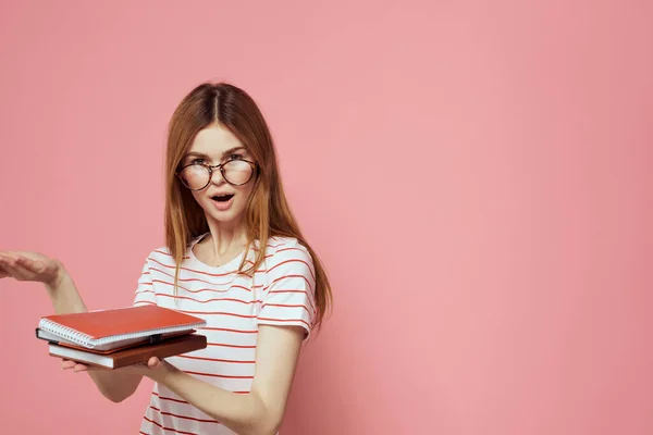 Jeune étudiante avec des livres sur les lunettes de fond roses sur le visage institut d'éducation vue recadrée — Photo