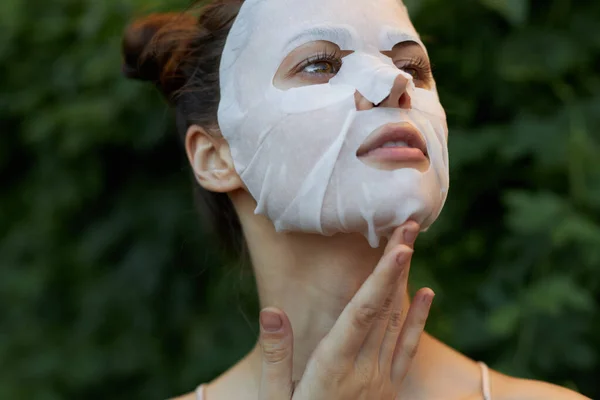 Belle femme masque blanc Incliné sa tête en arrière et dermatologie de coiffure à la mode feuilles en arrière-plan — Photo